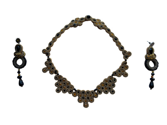 PHARAON ECLISSE unisce la profondità mistica dell’onice al calore radioso dell’agata gialla, intrecciati in un ricamo soutache ispirato ai tesori faraonici. Le sue linee sinuose brillano come un’eclisse dorata nel deserto,